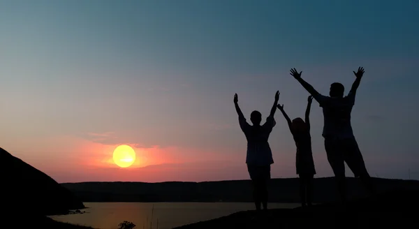 Familia de la trei persoane salută apusul soarelui — Fotografie, imagine de stoc