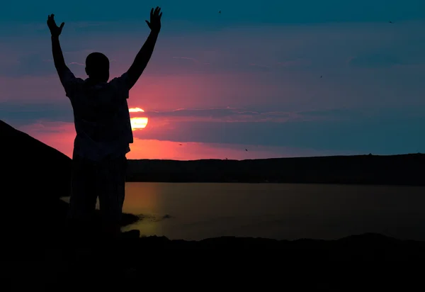 Der Mann begrüßt die Sonnenuntergangssonne — Stockfoto