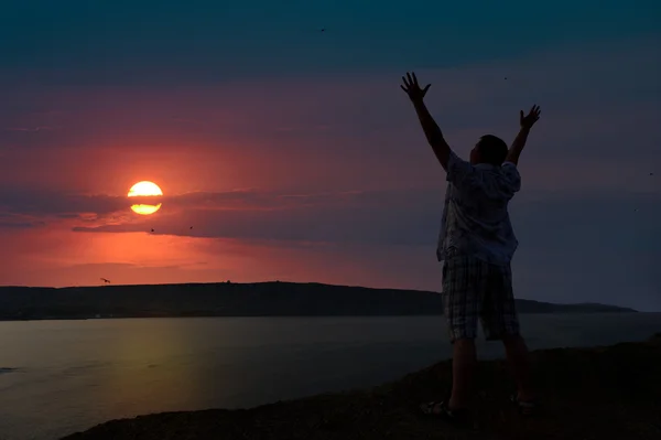 Der Mann begrüßt die Sonnenuntergangssonne — Stockfoto