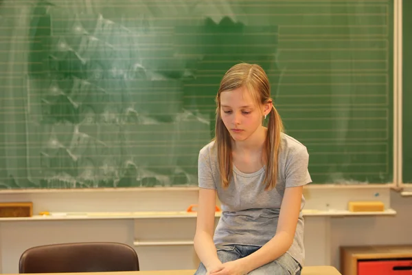 Szomorú szőke lány az iskolában Stock Kép