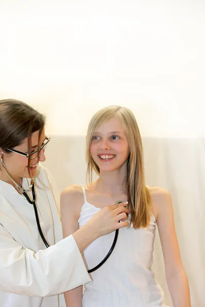 Junge Ärztin oder Krankenschwester untersucht lachendes Mädchen — Stockfoto