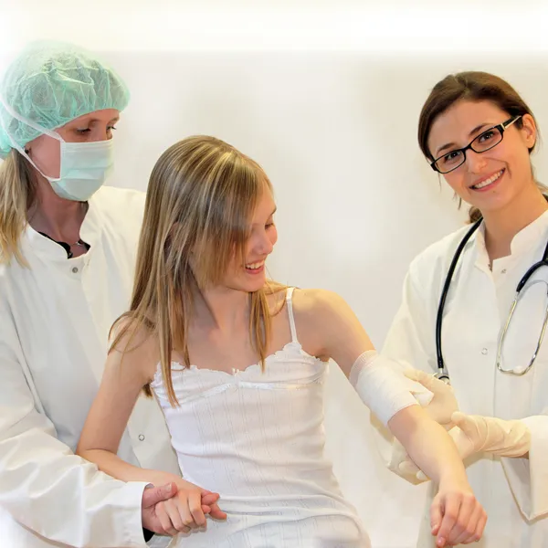 Médicos e enfermeiros se juntam ao braço ferido de uma criança — Fotografia de Stock