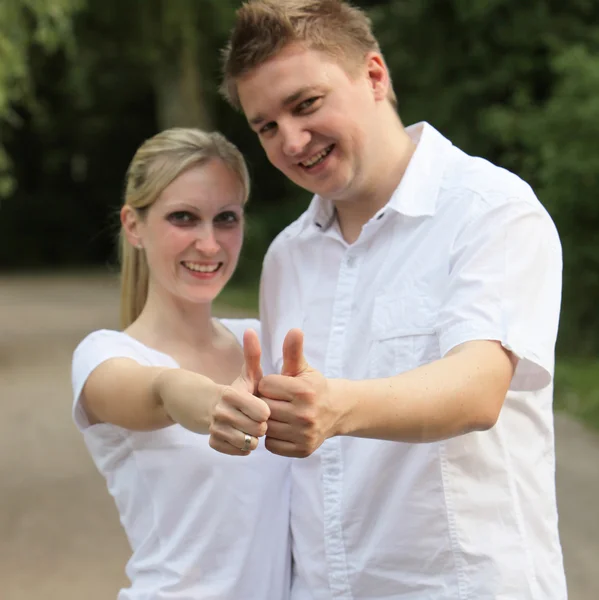 Jovem casal segurando o polegar — Fotografia de Stock