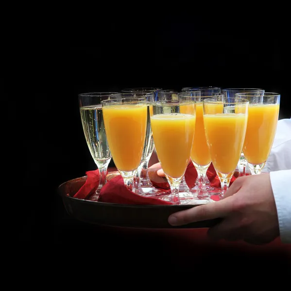 Официант подает апельсиновый сок и шампанское - площадь — стоковое фото