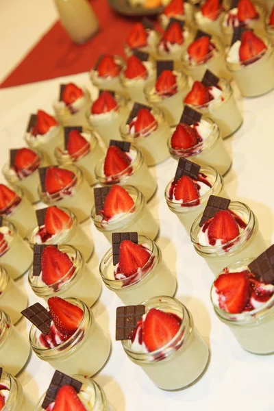 Muitas sobremesas doces com morangos e chocolate - servidas em — Fotografia de Stock