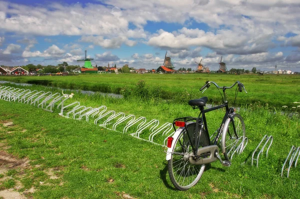 Велосипед на зеленой лужайке на фоне ветряных мельниц . — стоковое фото