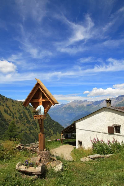 Drewniany krzyż w pobliżu wiejskiej rezydencji w Alpach. — Zdjęcie stockowe