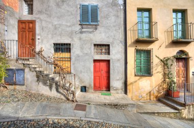 Wooden multicolored doors in the house in Saluzzo. clipart