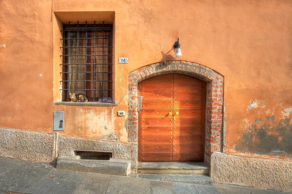 Wooden door and window with bars in Saluzzo. — Stock Photo, Image