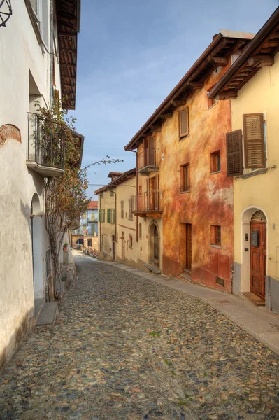 Enge gepflasterte straße zwischen häusern in saluzzo, italien. — Stockfoto