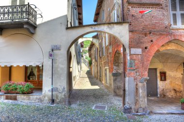 Old narrow street amont ancient houses in Avigliana, Italy. clipart