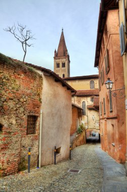Narrow paved street among houses in Saluzzo, Iyaly. clipart