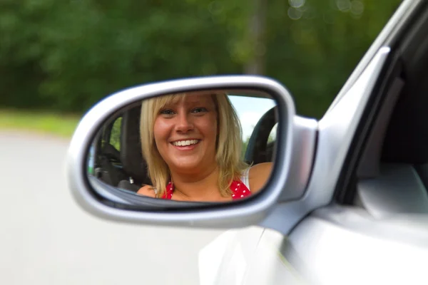 Женщина смотрит в зеркало автомобиля — стоковое фото
