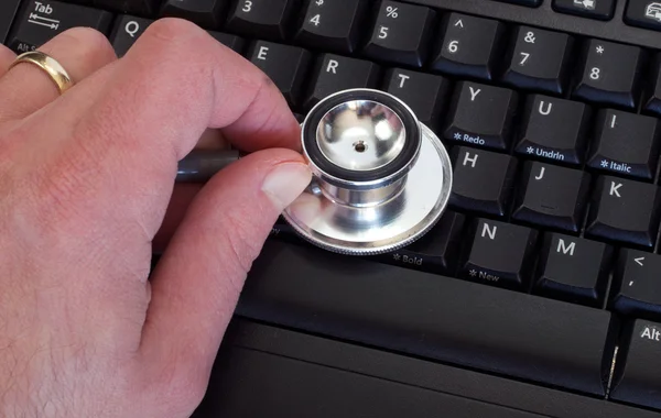 stock image Man Holding Stethoscope on Keyboard