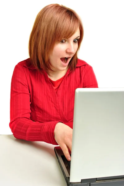 Office assistant in a red blouse working on a laptop — Stock Photo, Image