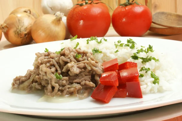 Kıyma pirinç ve beyaz bir plaka üzerinde kırmızı biber ile — Stok fotoğraf
