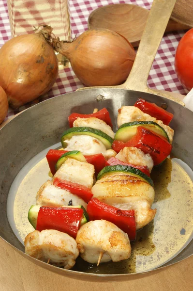 Chicken kebab in a brass pan with organic pepper — Stock Photo, Image
