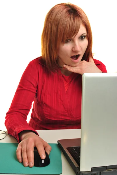 Office assistant in a red blouse working on a laptop — Stock Photo, Image