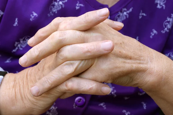 Les mains priantes d'une personne âgée avec un pull bleu foncé — Photo