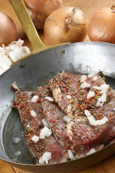 Peppered beef steak in an old brass pan — Stock Photo, Image