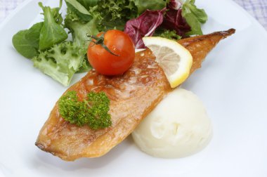 Smoked mackerel fillet with tomato on mash potato clipart