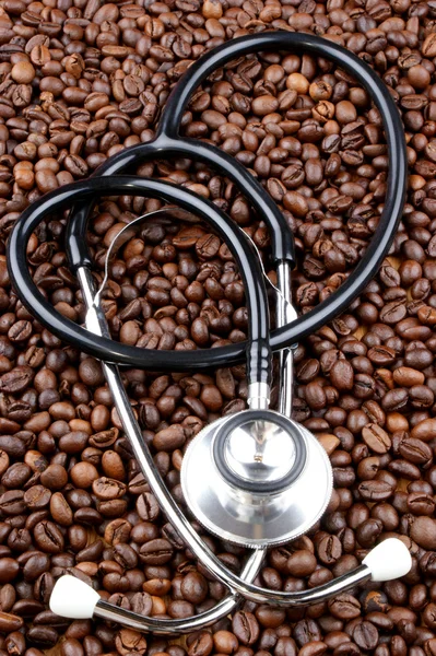 Grains de café fraîchement torréfiés et stéthoscope — Photo
