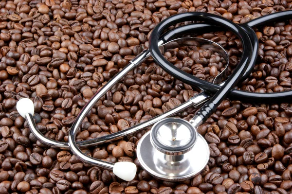 Свіжообсмажені кавові зерна та стетоскоп — стокове фото