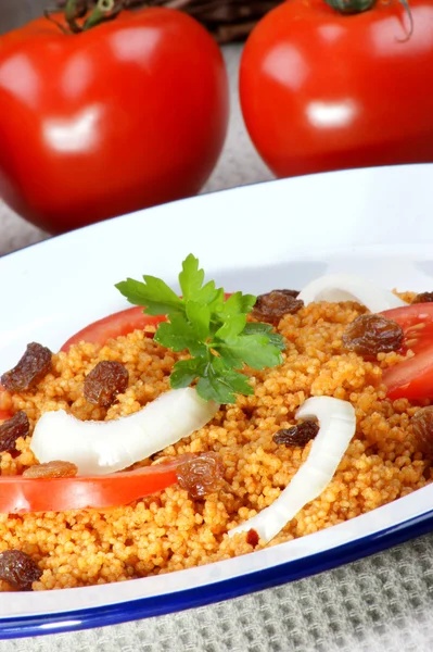 Couscous with onion rings and tomato pieces — Stock Photo, Image
