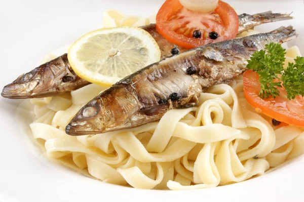 Some grilled sardines on tagliatelle and tomatoes — Stock Photo, Image