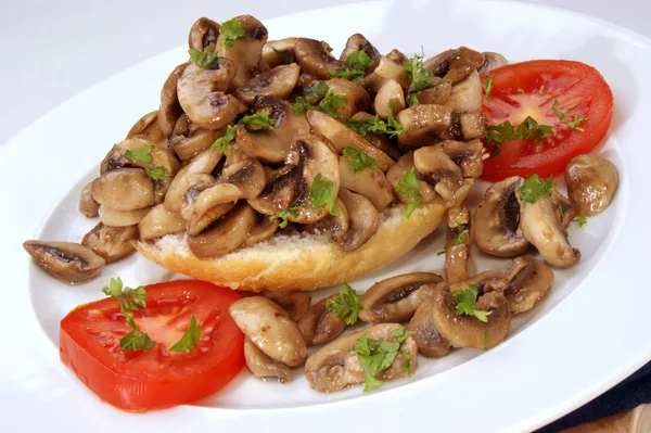 Fried mushrooms on half a bun with tomato — Stock Photo, Image