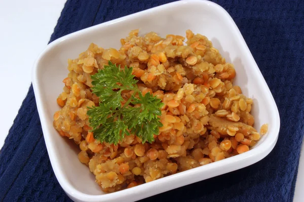 Stock image Red lentils cooked in a white bowl with parsley