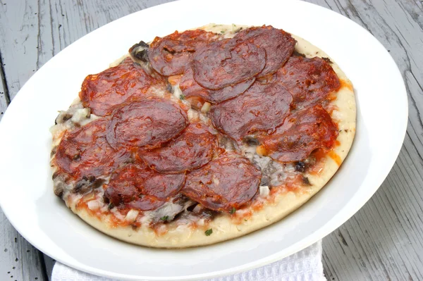 Pizza z salami ostre na białym talerzu — Zdjęcie stockowe