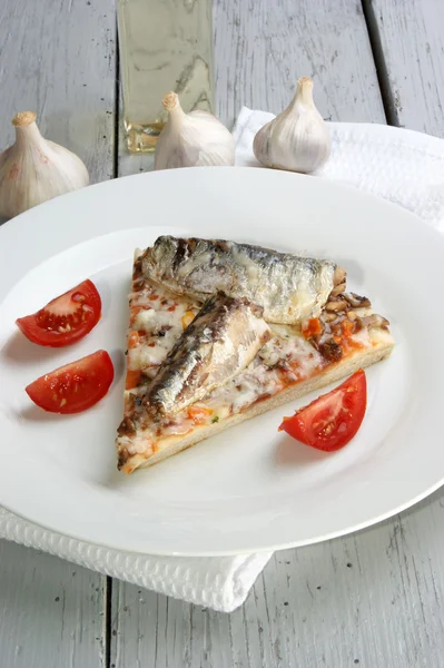Пицца с грибами и сардиной на белой тарелке — стоковое фото