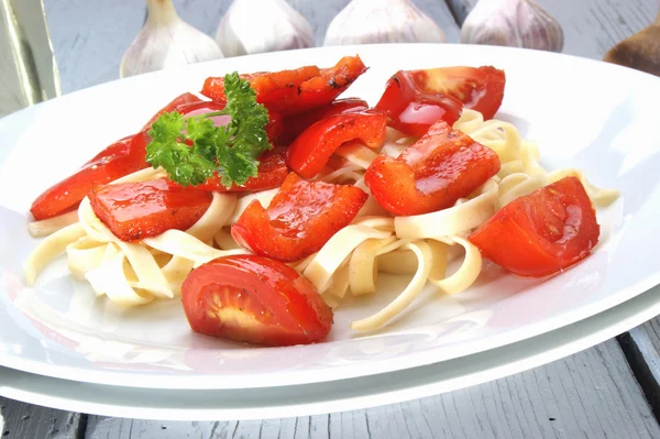 Geröstete rote Paprika mit Tomaten auf Nudeln — Stockfoto