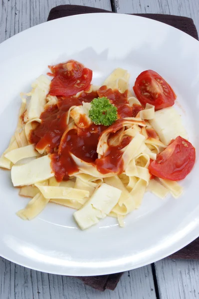 Těstoviny s rajčatovou omáčkou a pečeným kozím sýrem — Stock fotografie