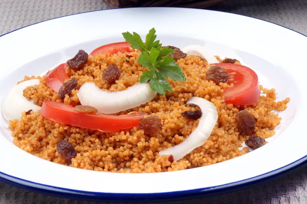 Couscous with onion rings and tomato pieces — Stock Photo, Image