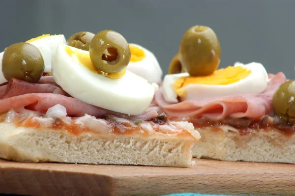 Pizza con prosciutto, uova e qualche oliva — Foto Stock