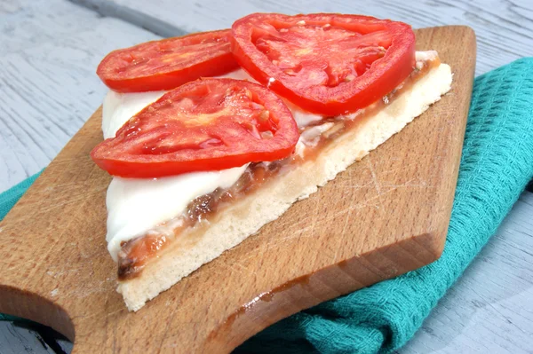 木製のボード上のモッツァレラチーズとトマトのスライスのピザ — ストック写真