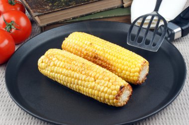 Grilled corn on the cob in a pan clipart