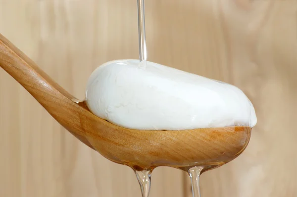 Mozzarella com óleo de azeitona em uma colher de madeira — Fotografia de Stock