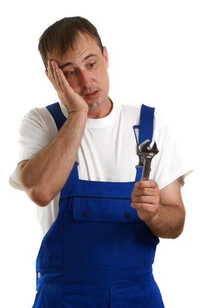 Craftsmen in blue overalls holding a box spanner — Stock Photo, Image
