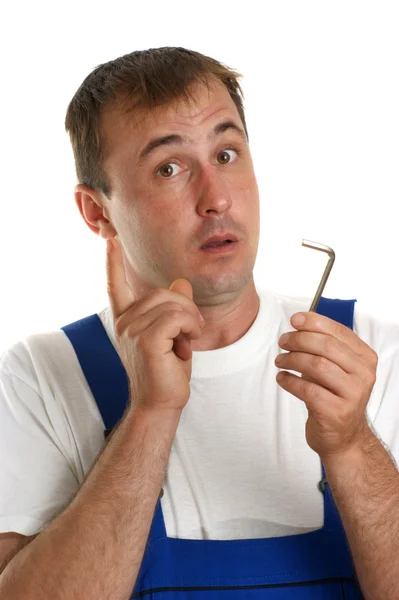 Craftsmen in blue overalls holding an allen key — Stock Photo, Image