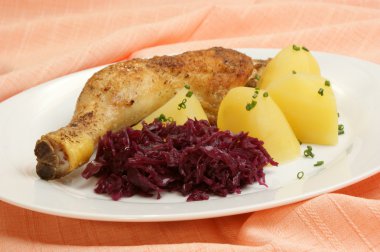 Grilled chicken drumstick with potatoes and red cabbage clipart