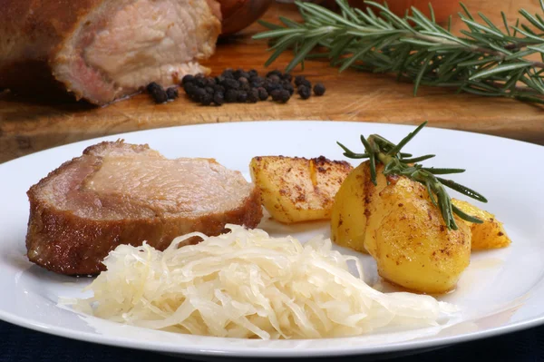 Geroosterd varkensvlees met gebraden aardappels en zuurkool — Stockfoto