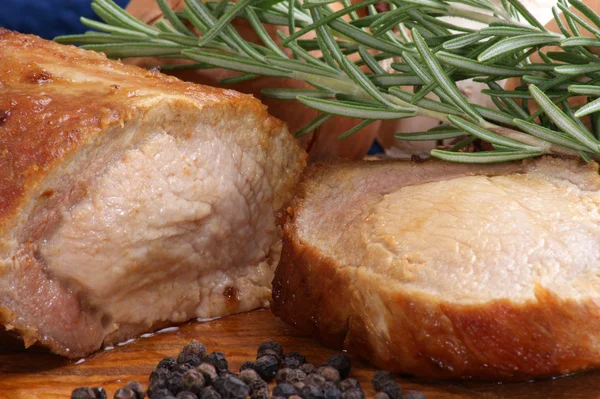 Roast pork with rosemary on a wooden board — Stock Photo, Image