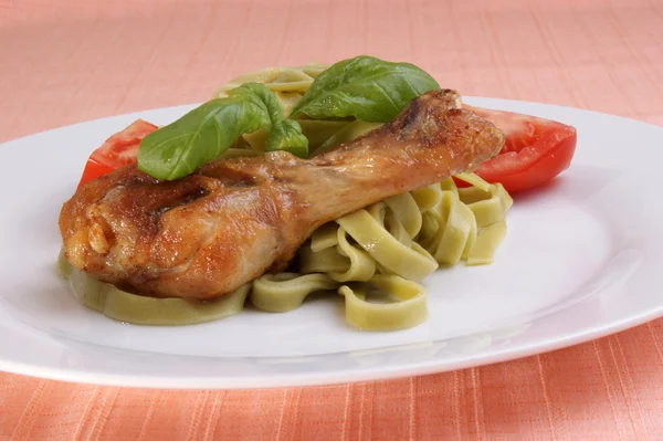 Grilled chicken thigh on tagliatelle with basil — Stock Photo, Image