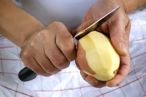 One potato is peeled with a kitchen knife — Stock Photo, Image