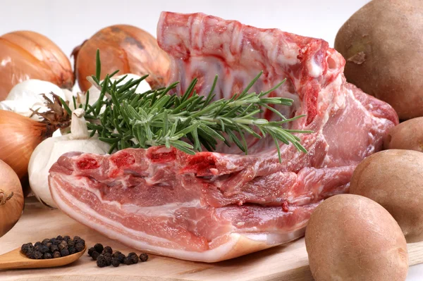 Сырая свинина с розмарином, картофелем и луком — стоковое фото