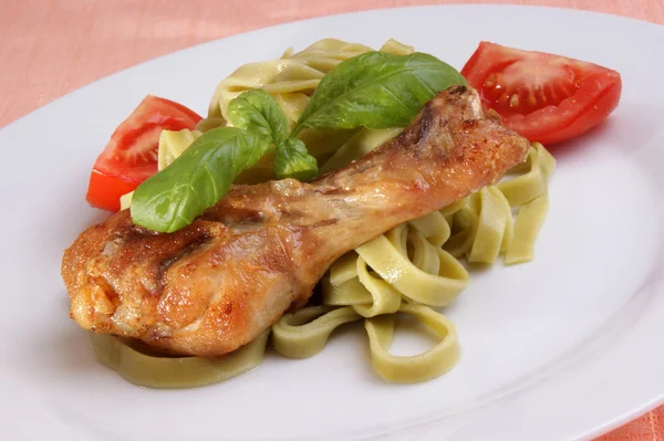 Grilled chicken thigh on tagliatelle with basil — Stock Photo, Image