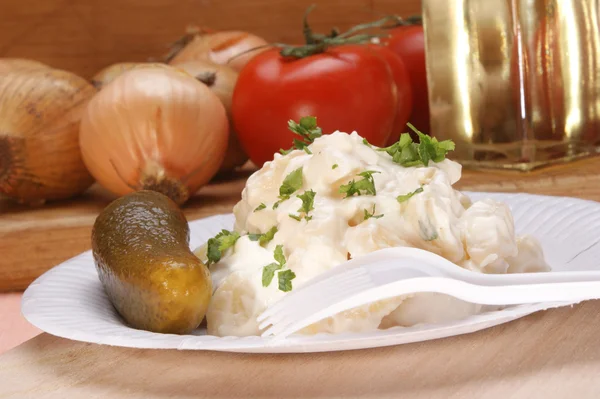 Aardappelsalade met pickles op een papier-plaat — Stockfoto